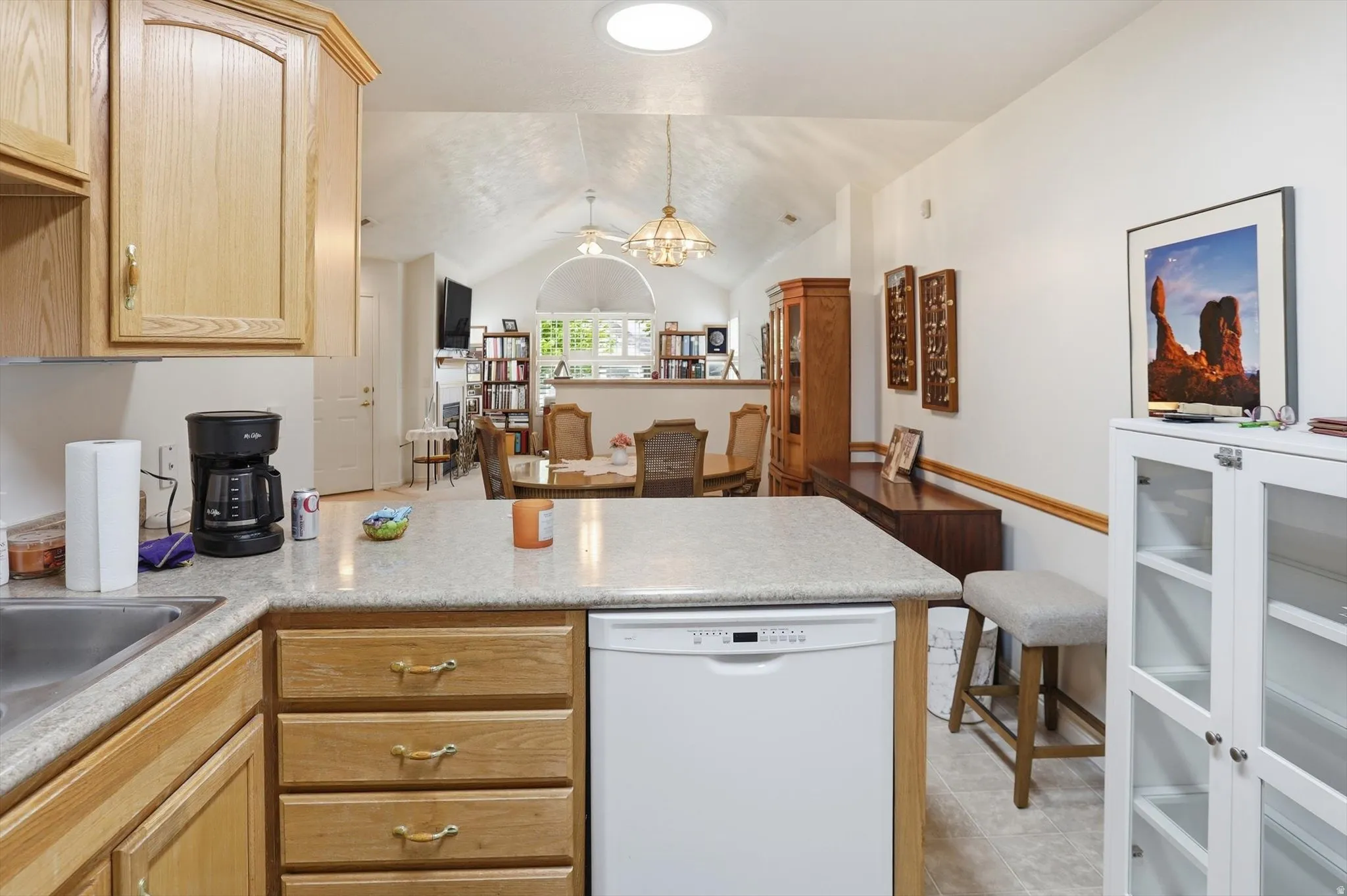 Kitchen featuring a built-in dishwasher, wood cabinetry, and a light-toned countertop