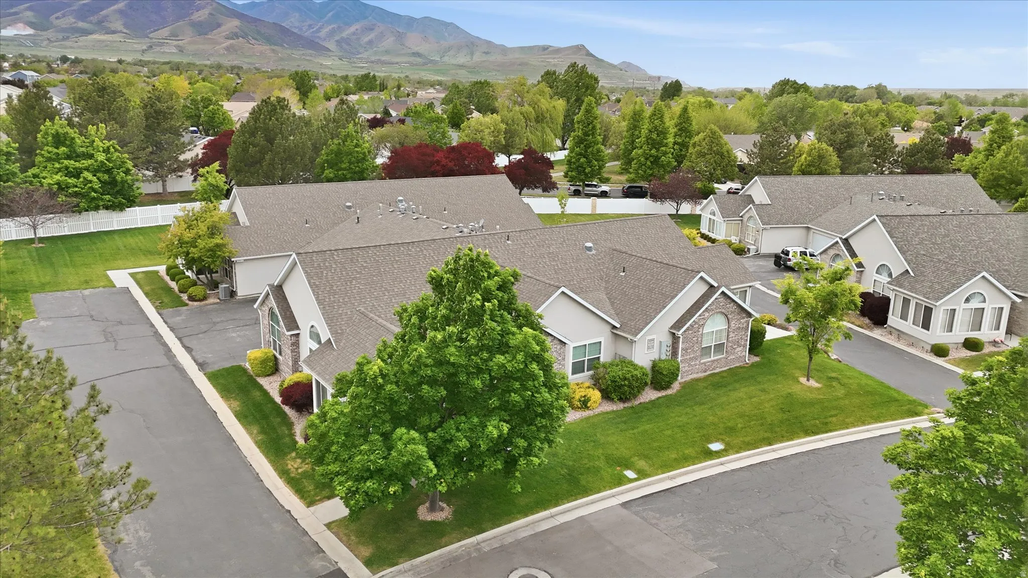 Aerial perspective showcasing a residential community with mature landscaping and mountain scenery
