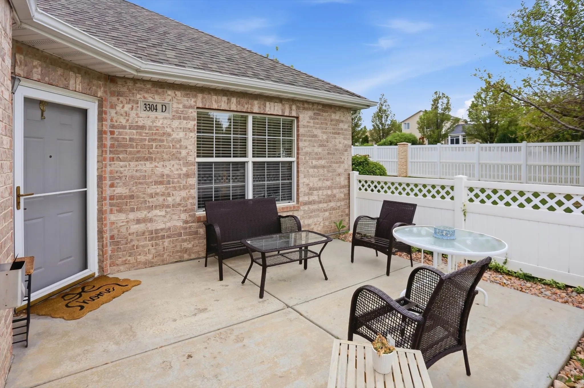 Private concrete patio featuring a partial lattice privacy fence