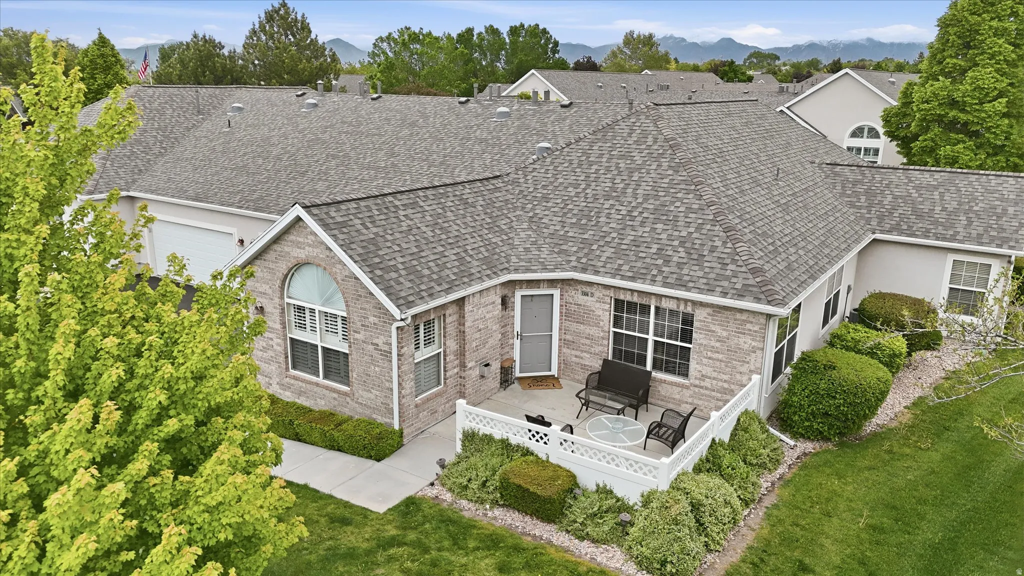 Brick exterior residence featuring an arched window, white trim, and a private patio space