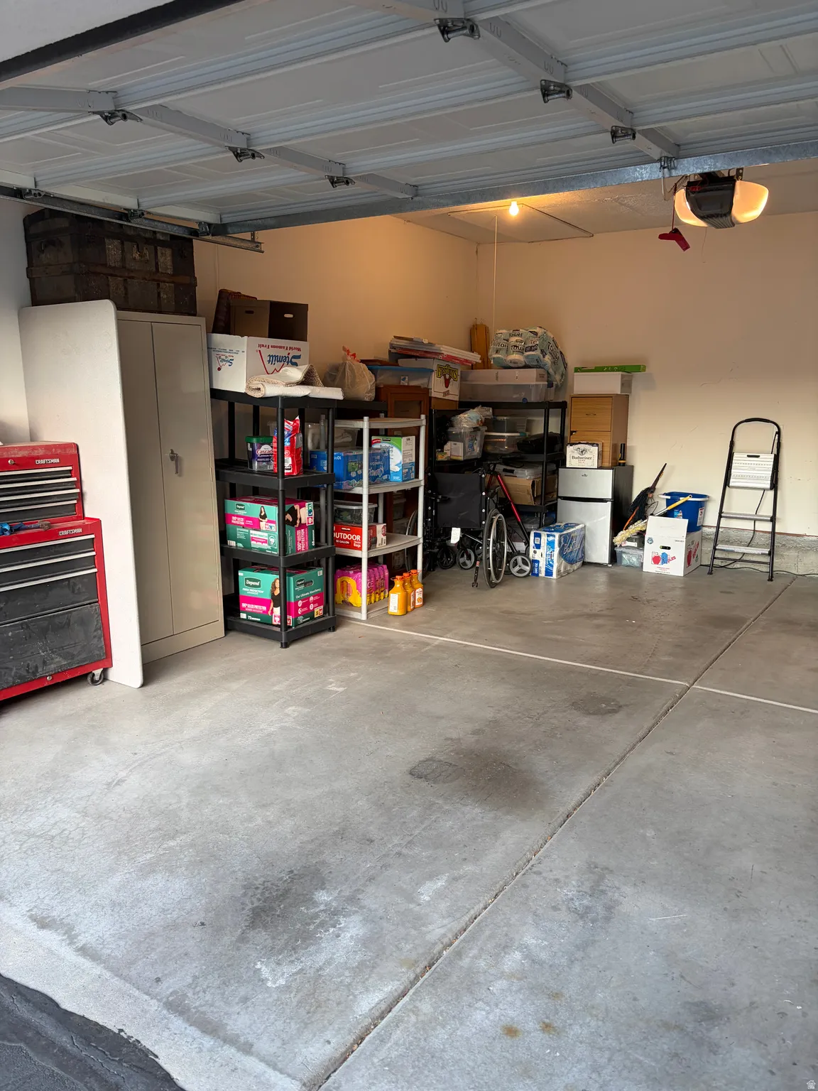 Garage featuring freestanding refrigerator and a garage door opener