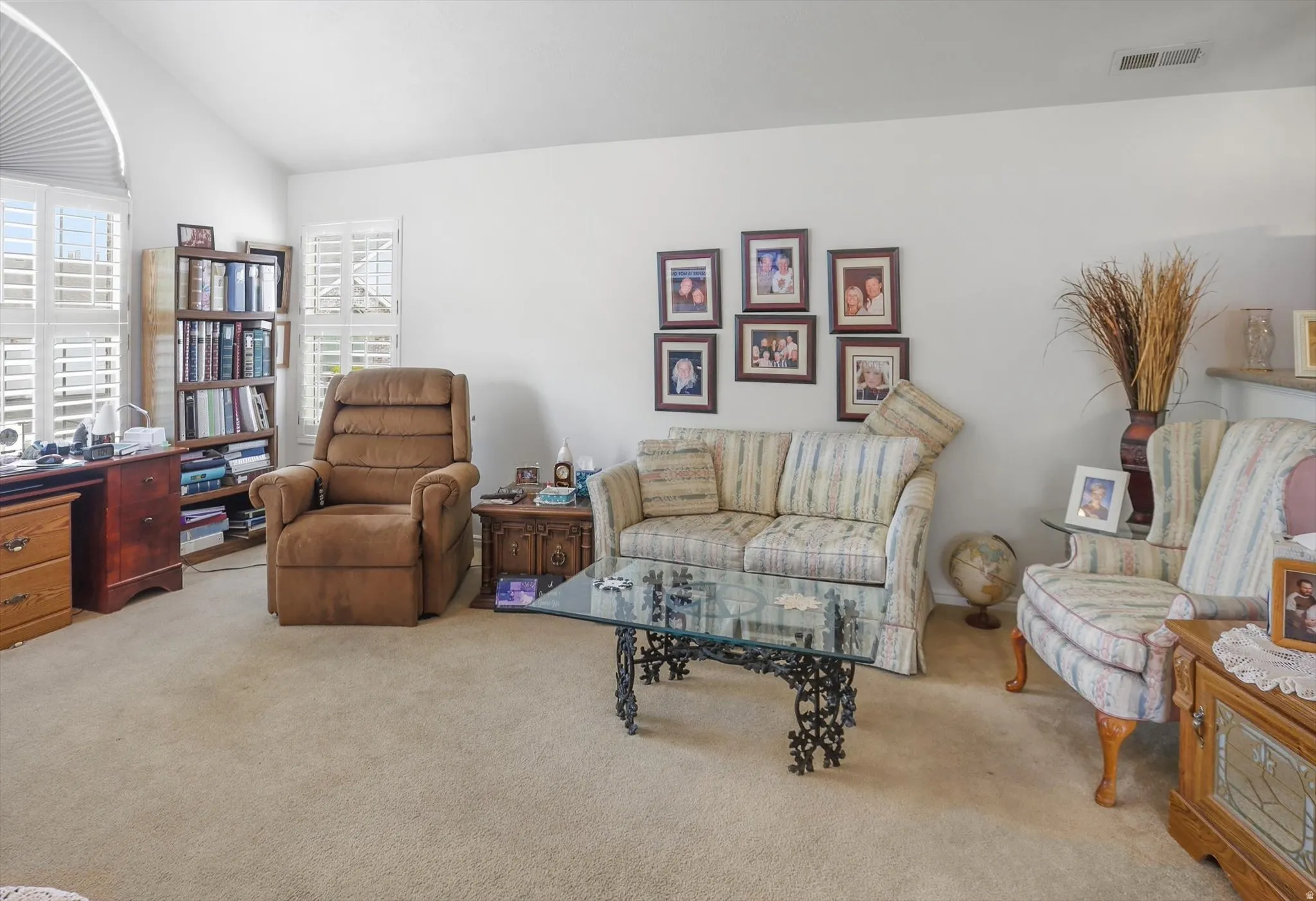 Spacious interior featuring vaulted ceilings and a neutral carpeted floor