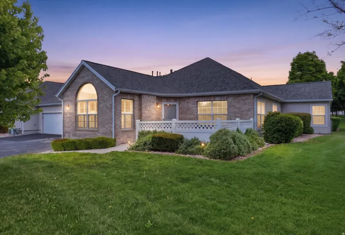 Brick and siding exterior featuring an arched window with interior shutters