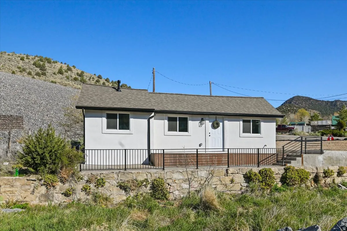 View of front facade with roof with shingles and a mountain view