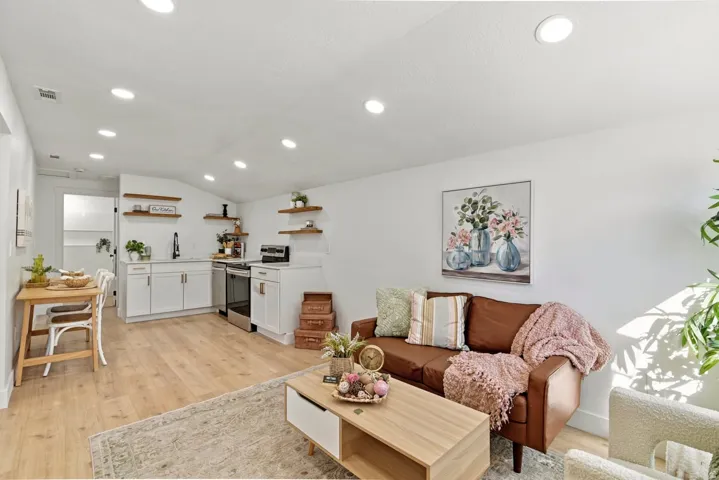 Living area with light wood finished floors, lofted ceiling, and recessed lighting