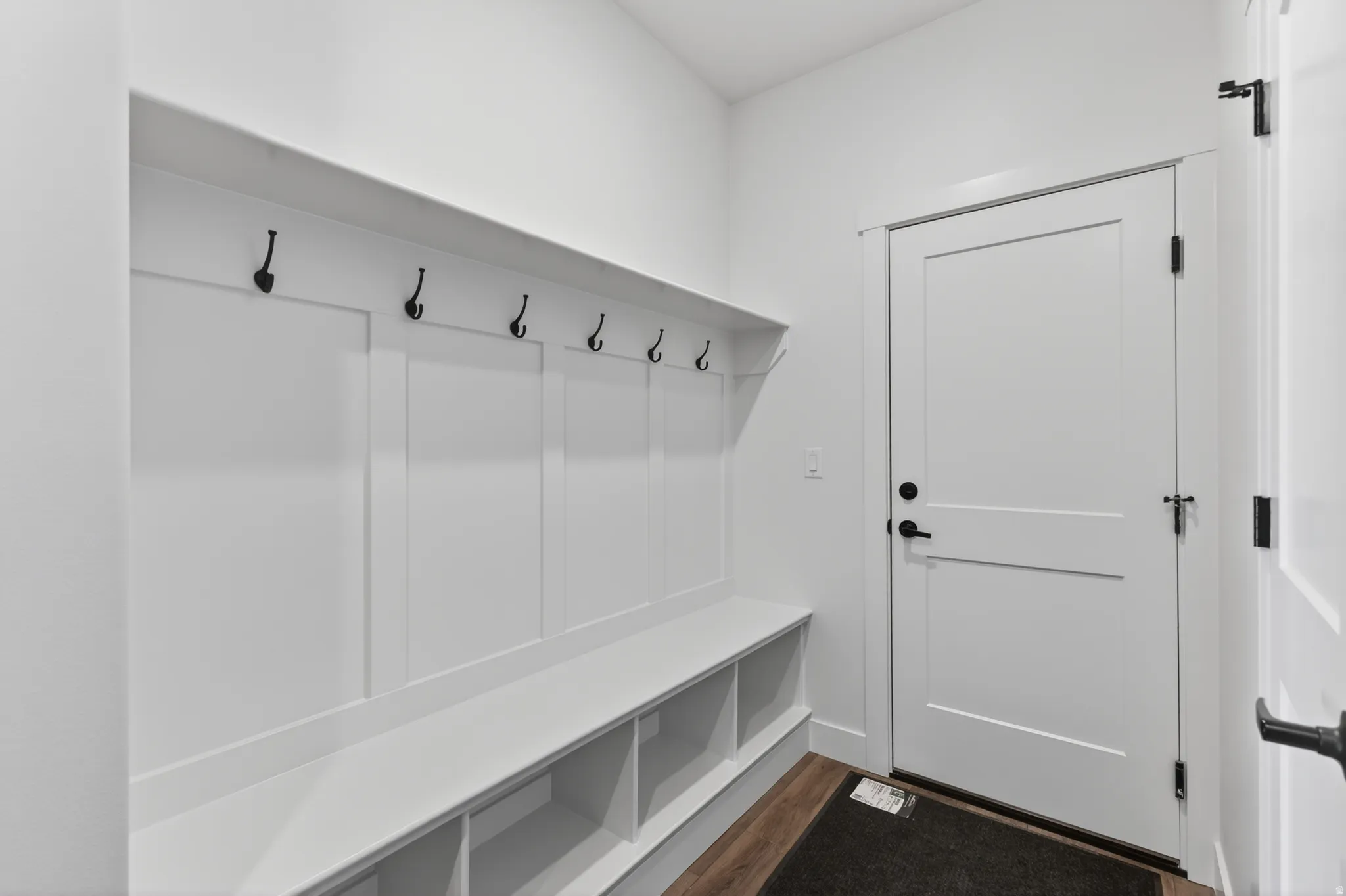 Built-in mudroom bench with cubby storage and black coat hooks