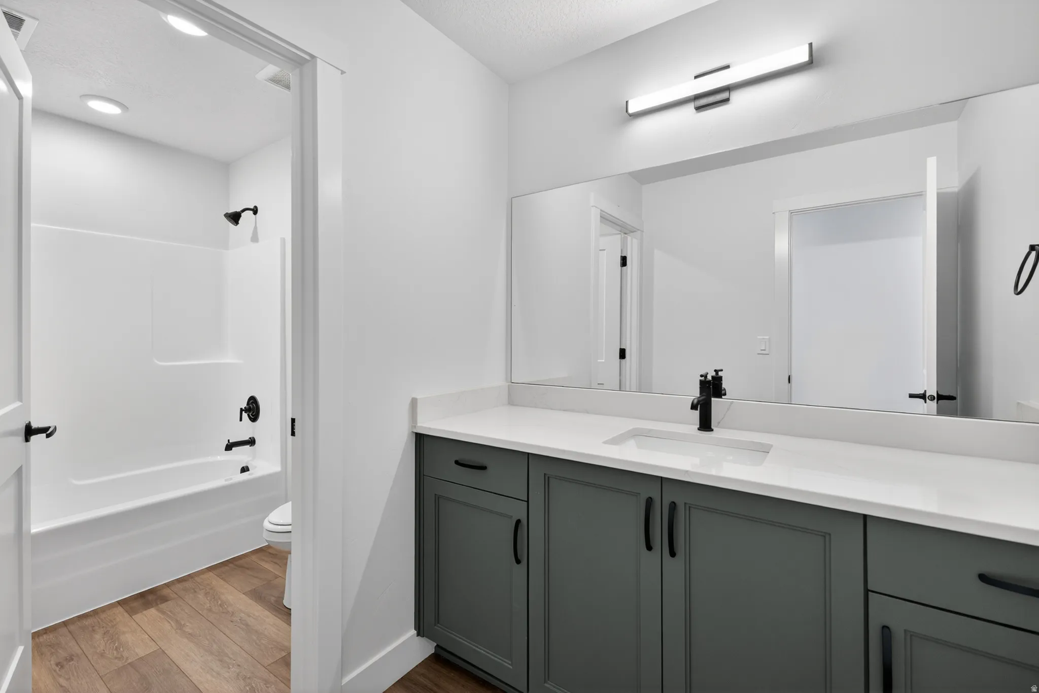 Bathroom featuring a contemporary vanity with a white countertop, an undermount sink, and a matte black faucet