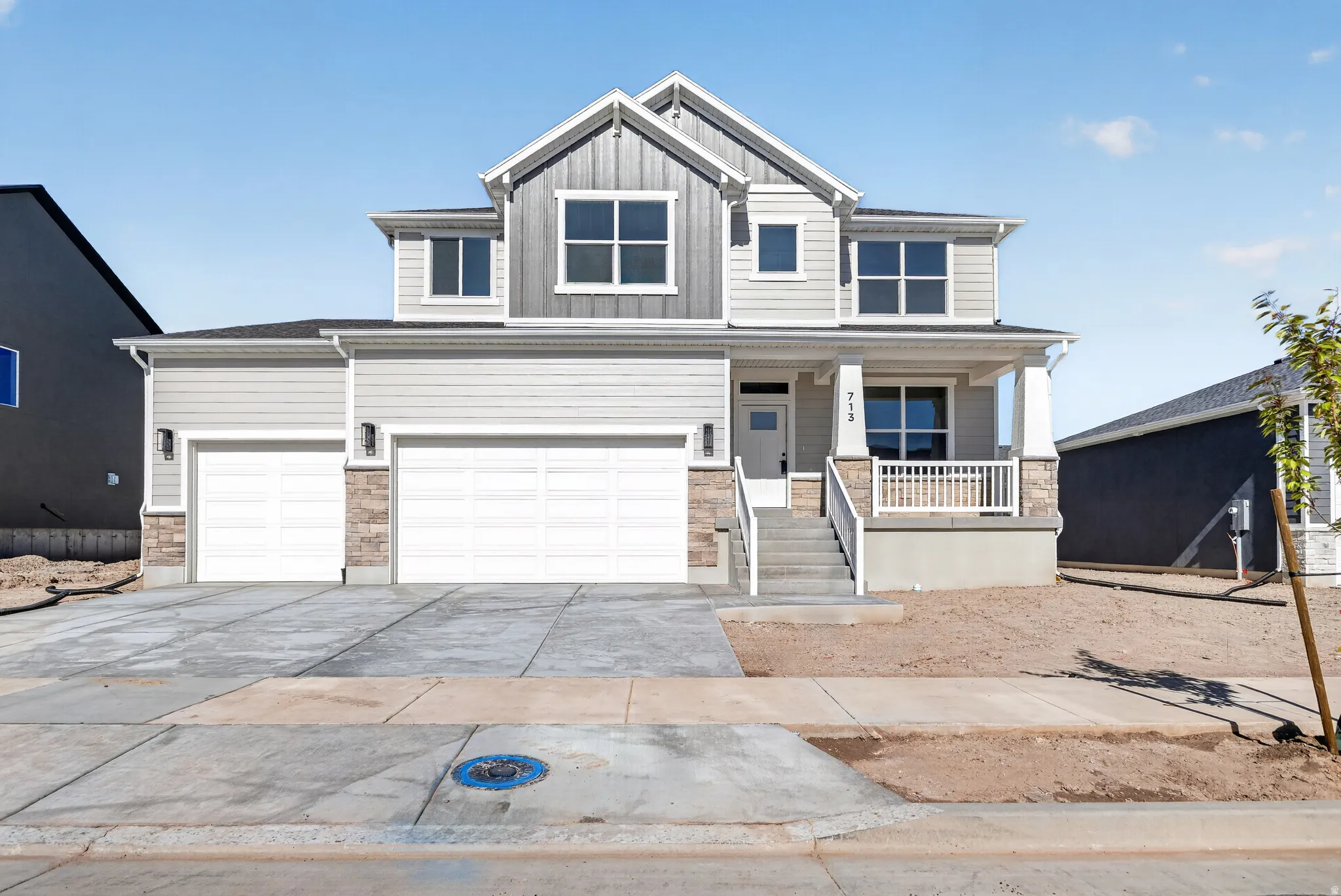Contemporary two-story exterior with light gray siding and stone accents