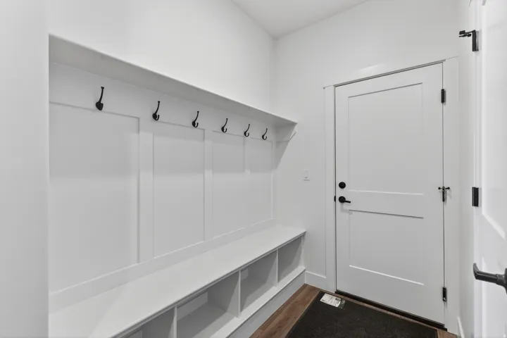 Built-in mudroom bench with cubby storage and black coat hooks