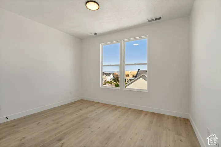 Light wood-finish flooring complements crisp white walls
