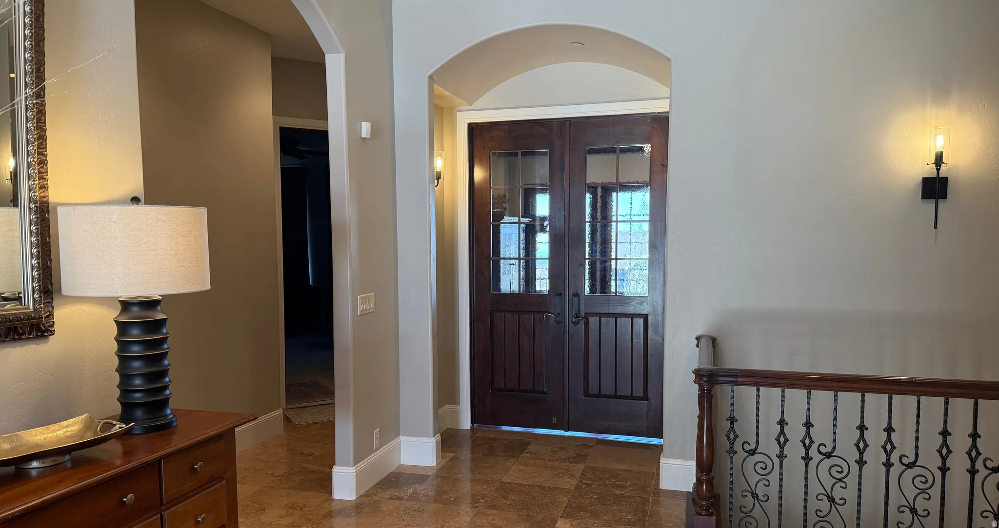 Grand entryway featuring double wood-paneled doors with divided light glass