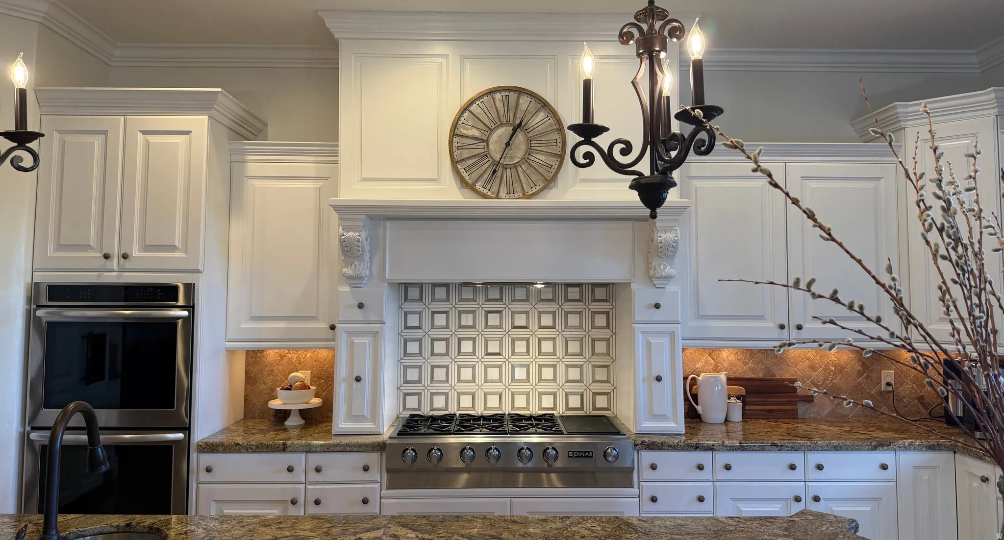 Gourmet kitchen with white cabinetry, stainless steel double ovens, a six-burner gas range, a decorative tile backsplash, and stone countertops