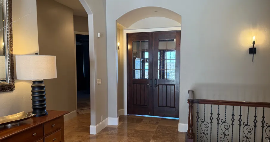 Grand entryway featuring double wood-paneled doors with divided light glass