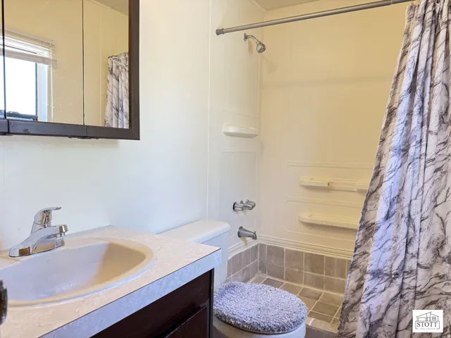 Full bathroom featuring a shower with shower curtain and vanity