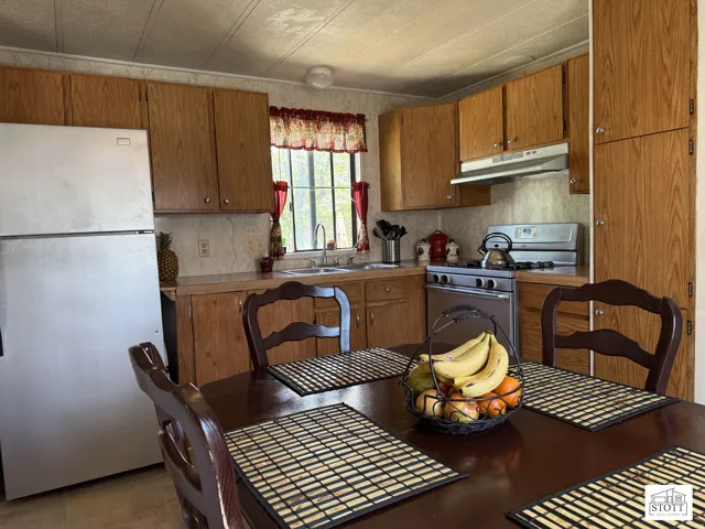 Kitchen featuring white appliances and wood finish cabinets