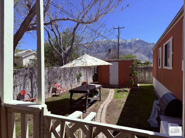 Fenced backyard with a storage shed and a mountain view