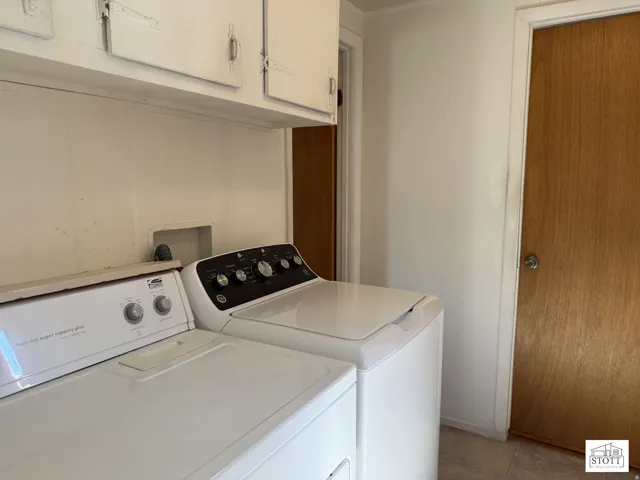 Laundry room featuring separate washer and dryer and cabinet space