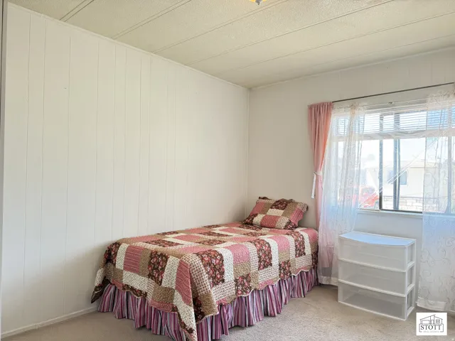 Bedroom featuring light carpet and wood walls