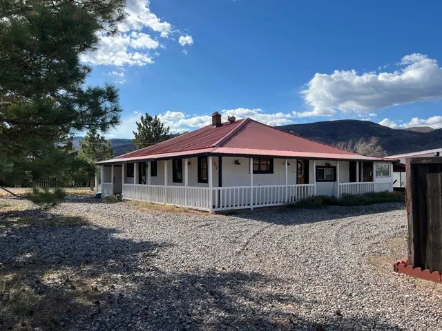 View of front of home with a mountain view, covered porch, a metal roof, and a chimney