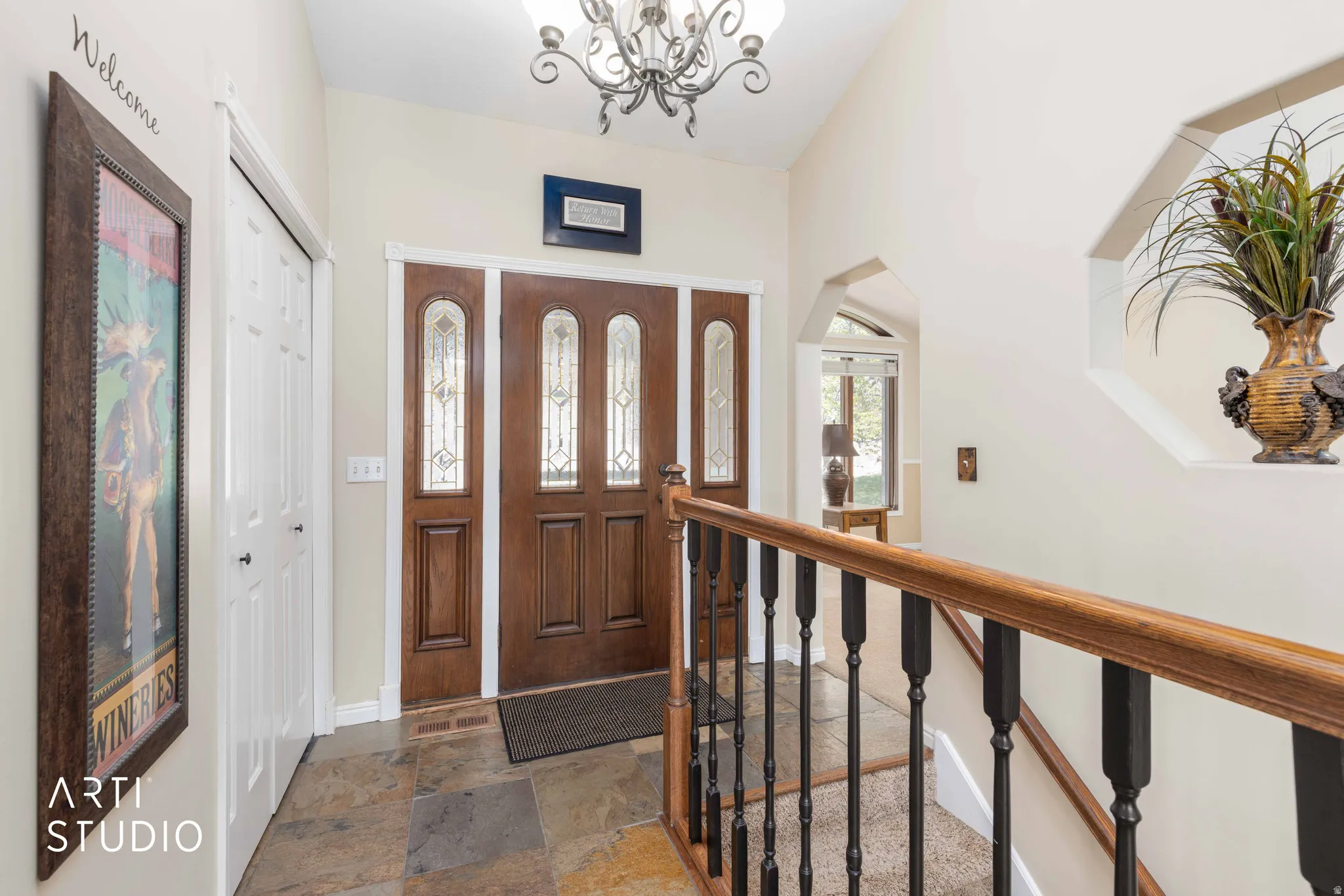 Entryway featuring stone tile flooring and suspended lighting