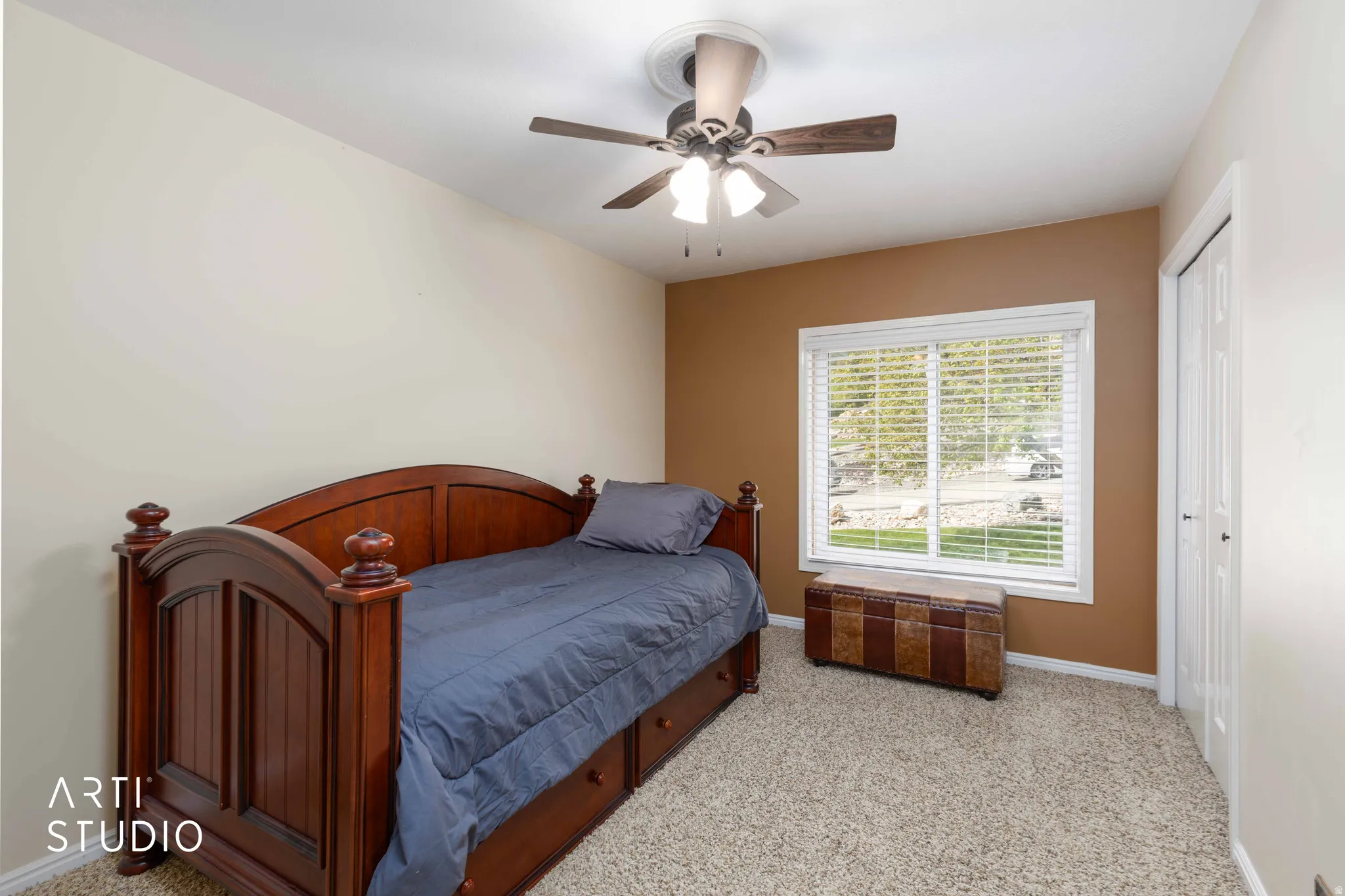 Bedroom with light colored carpet, ceiling fan, and a closet