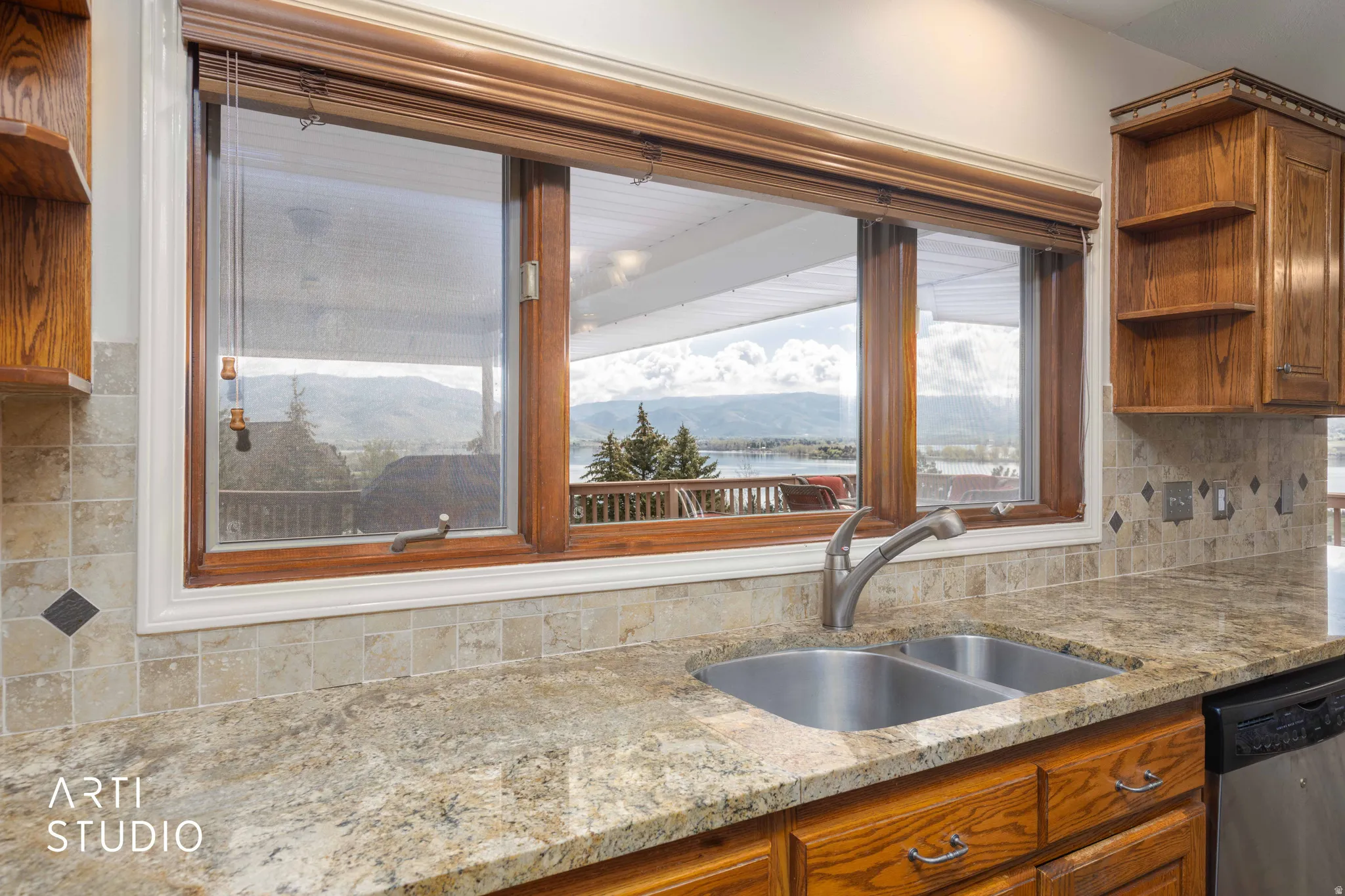 Kitchen featuring open shelves, light stone counters, wood finish cabinetry, stainless steel dishwasher, and a mountain view