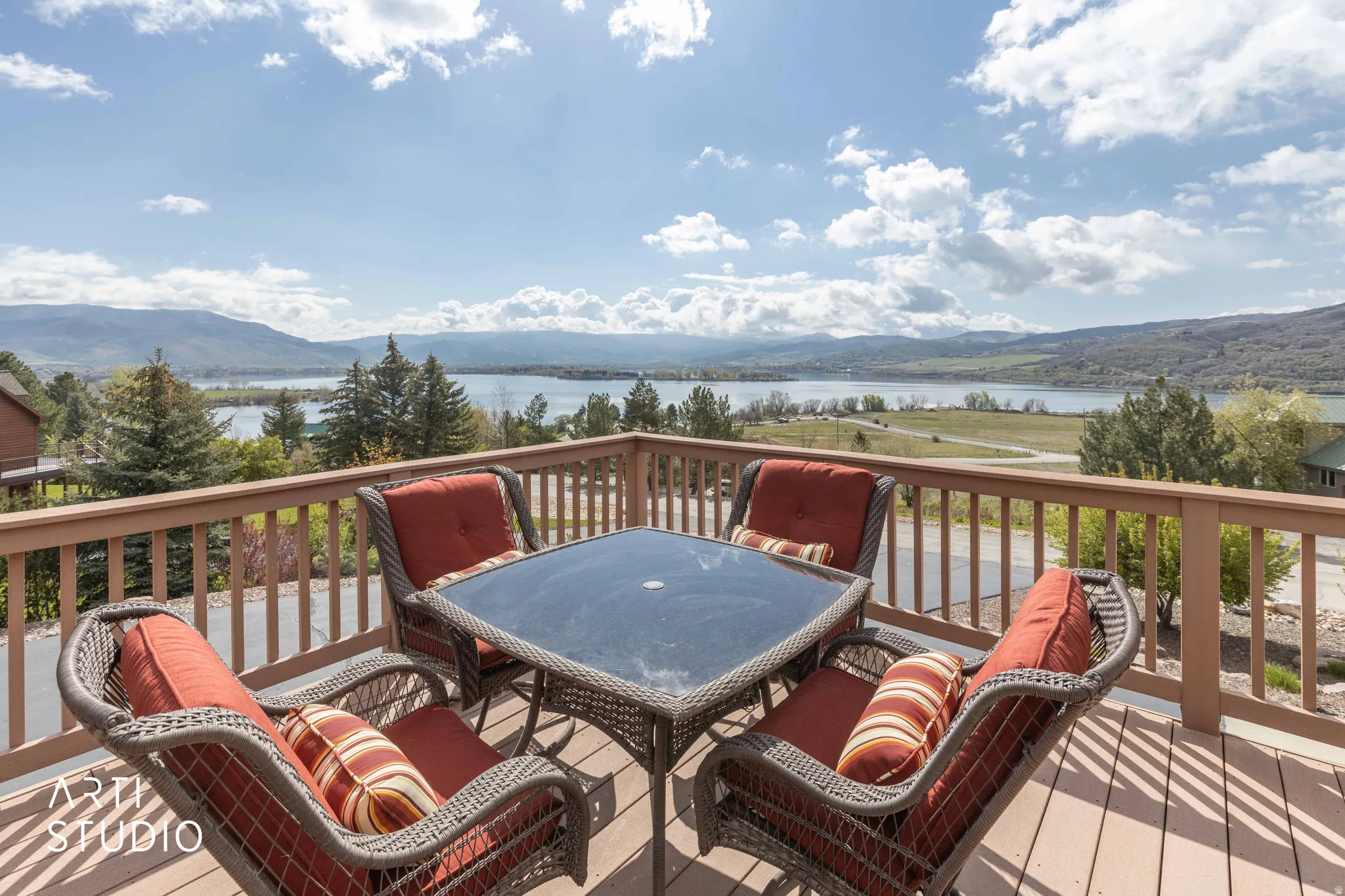 Wooden terrace with a water and mountain view and outdoor dining area