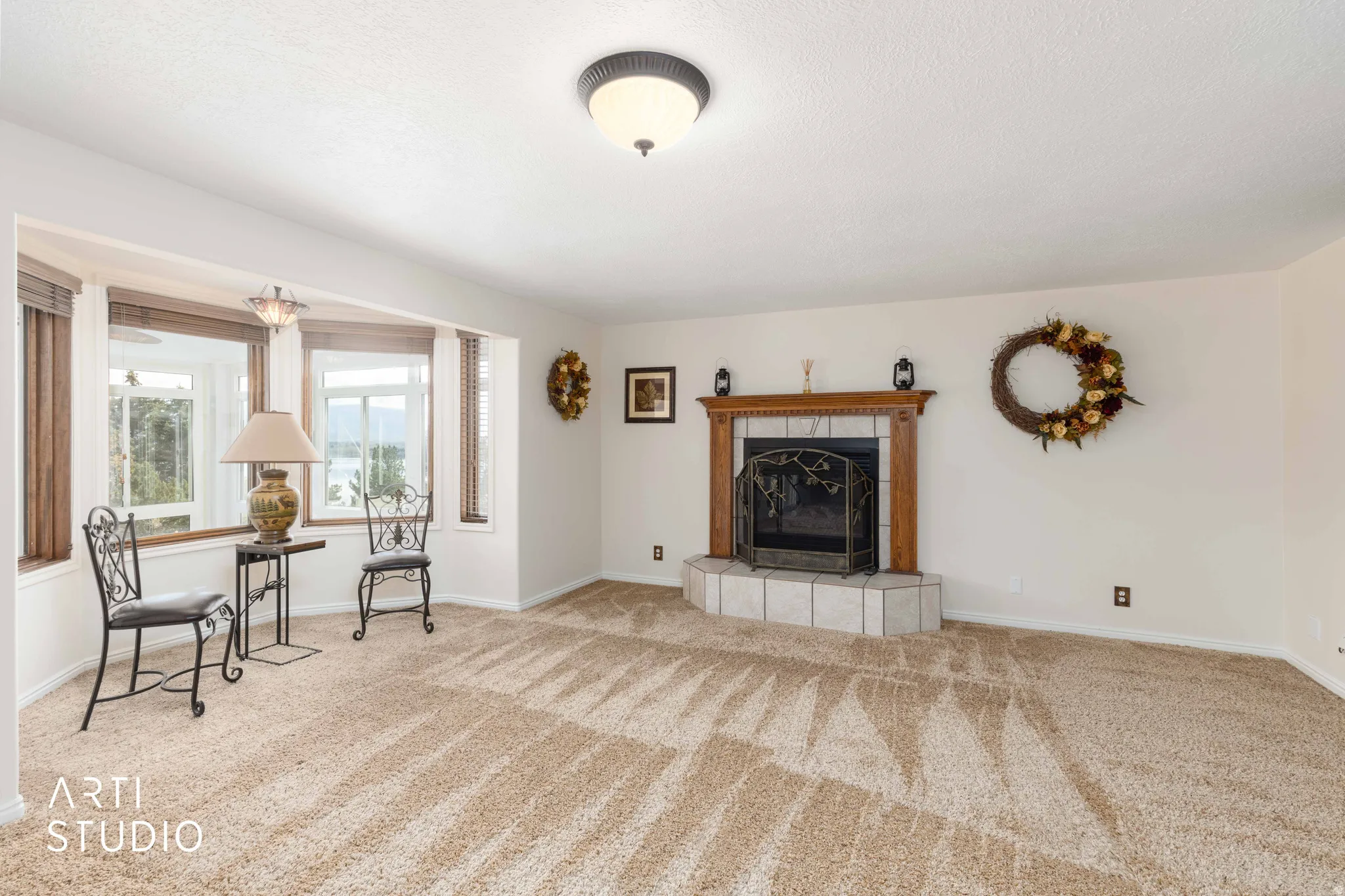 Sitting room featuring a tile fireplace and light carpet