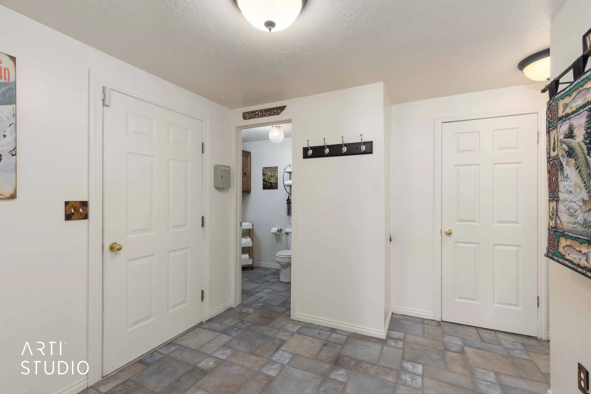 Corridor featuring stone finish floors and a textured ceiling