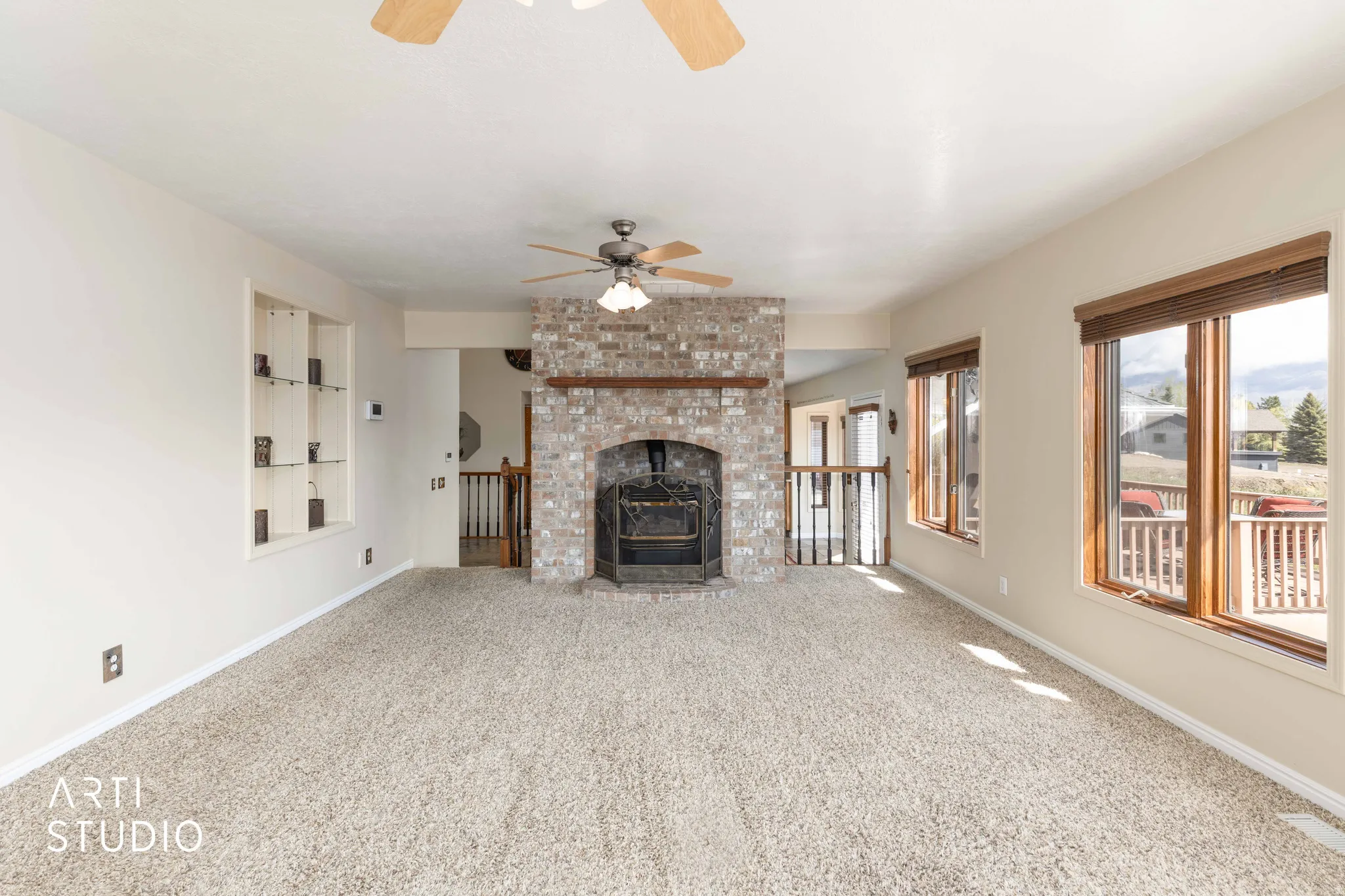 Unfurnished living room with a ceiling fan, carpet floors, and a fireplace
