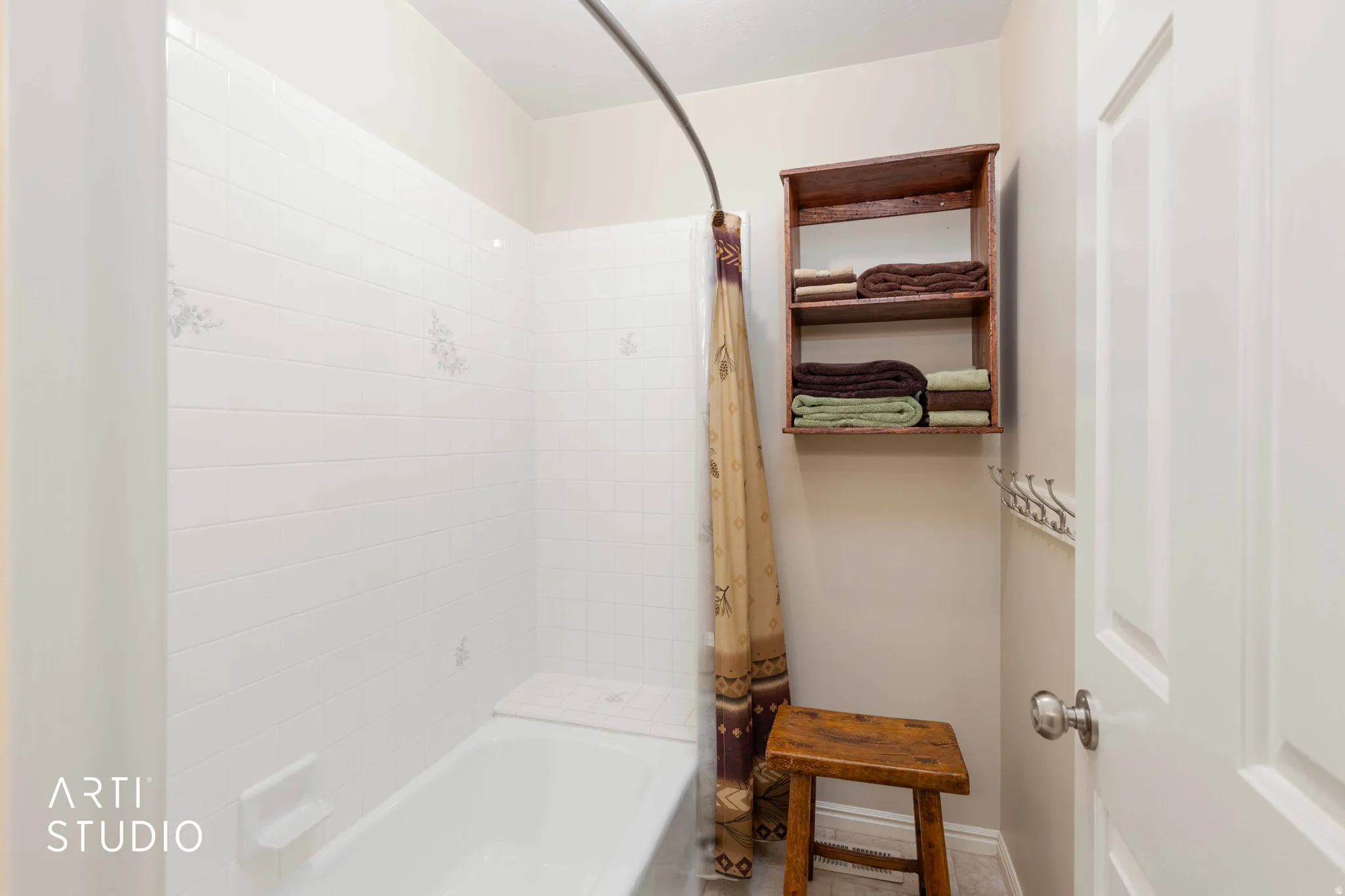 Bathroom featuring shower / bath combination with curtain and baseboards
