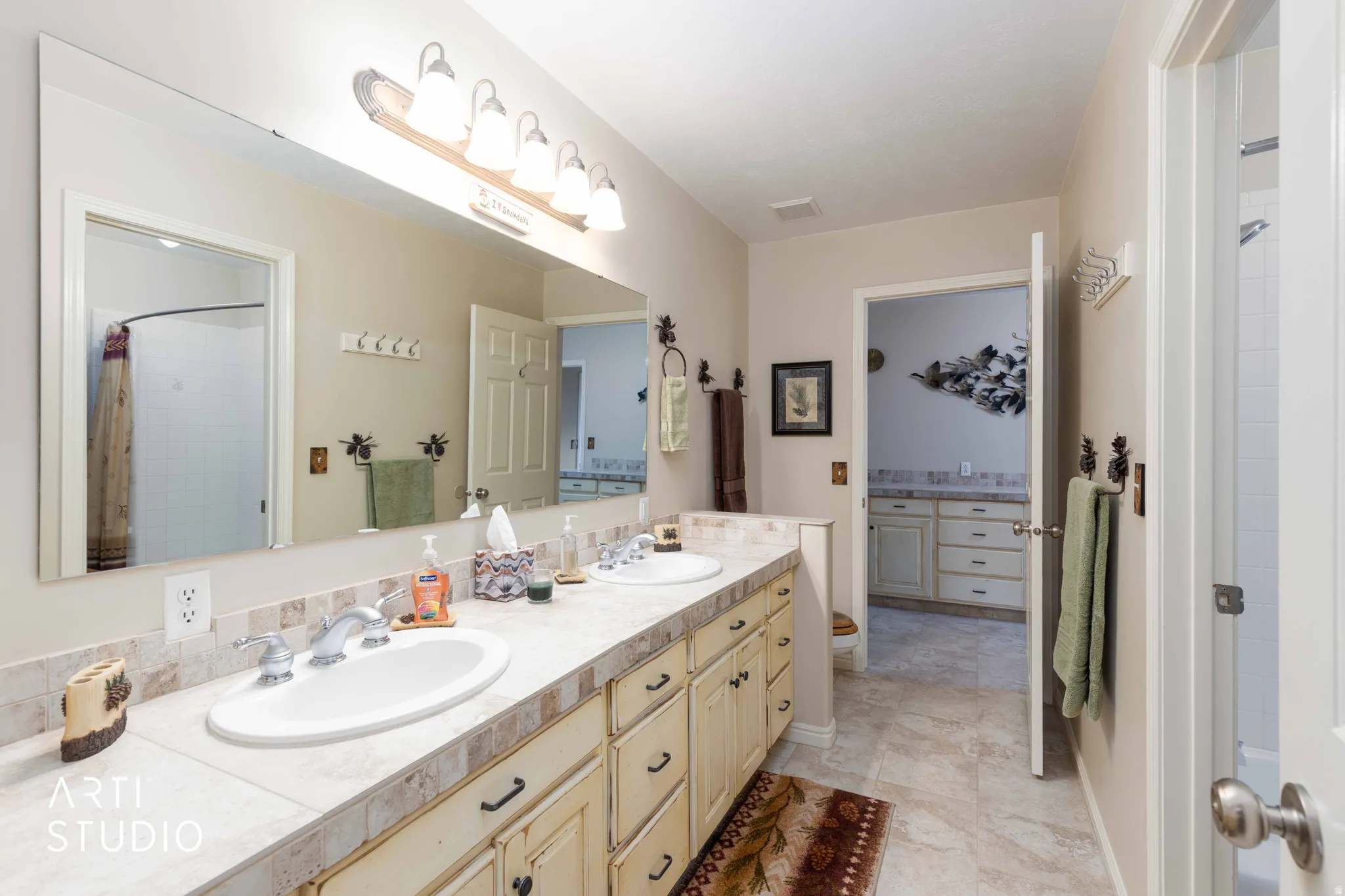 Bathroom with double vanity and a shower with shower curtain