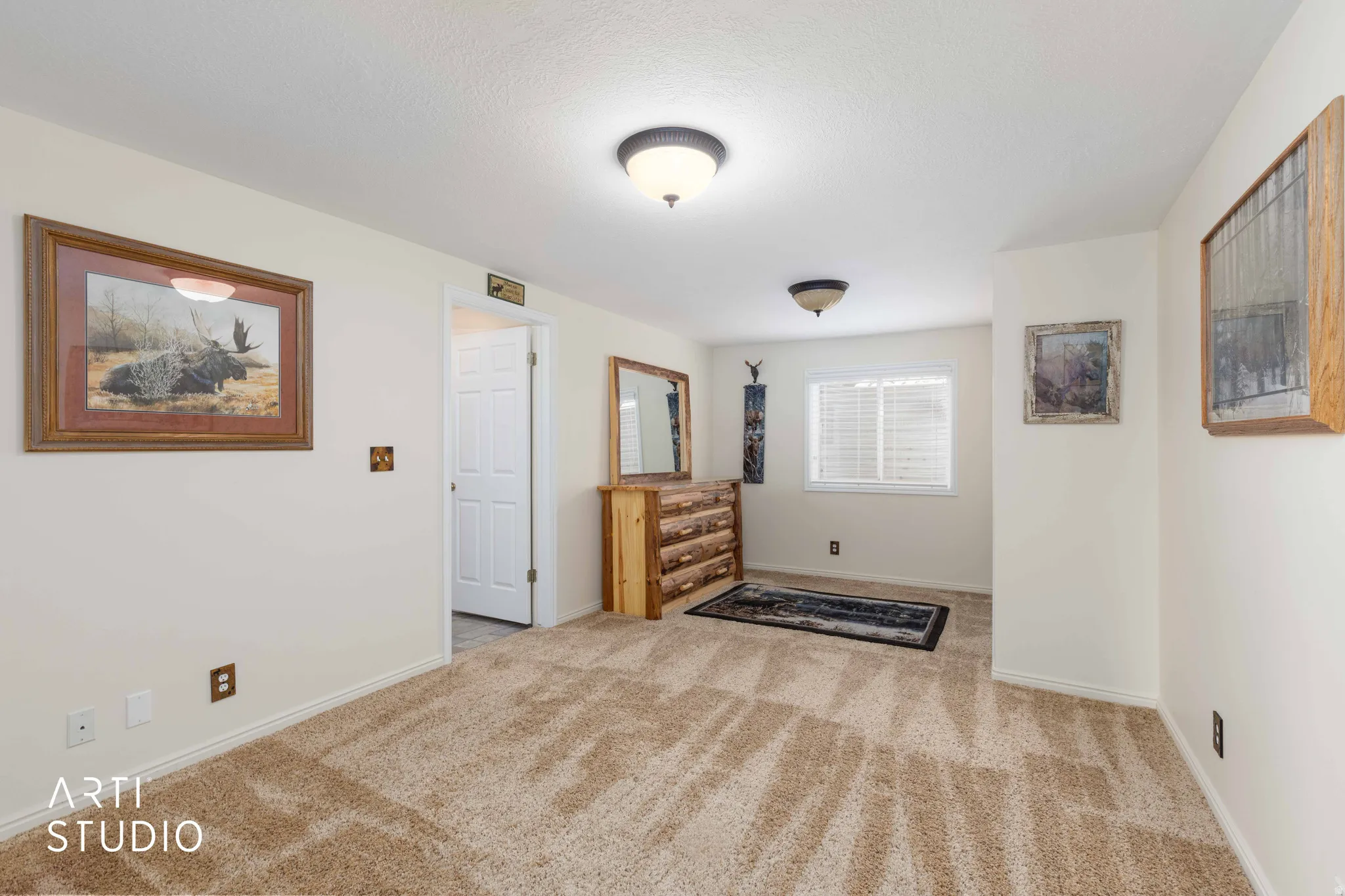 Unfurnished bedroom with light colored carpet and baseboards