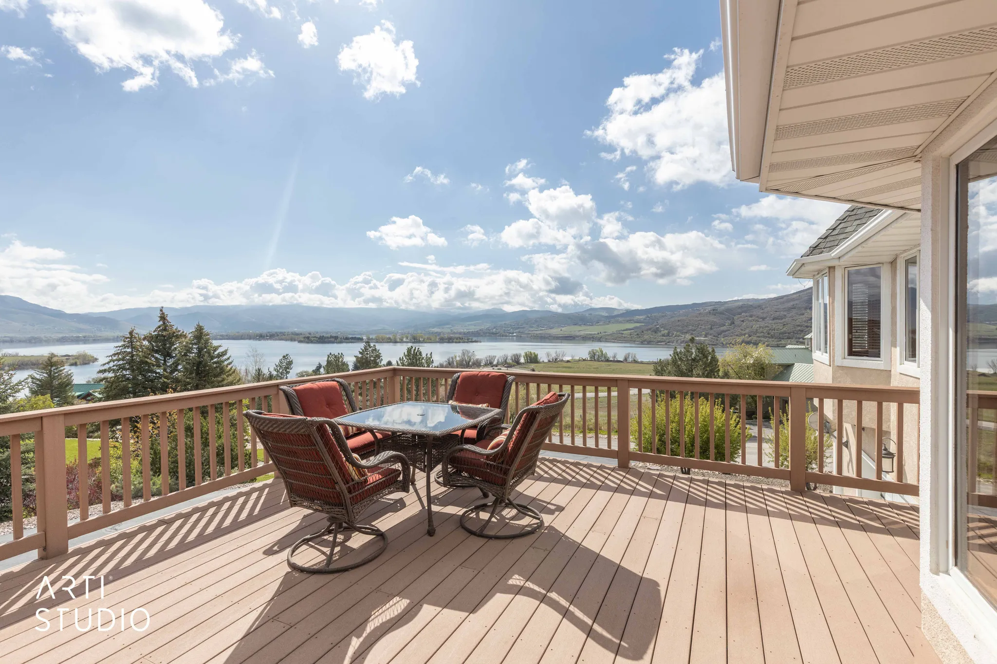 Wooden deck with outdoor dining space and a water and mountain view