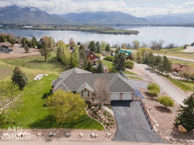 Aerial view of property and surrounding area featuring a water and mountain view