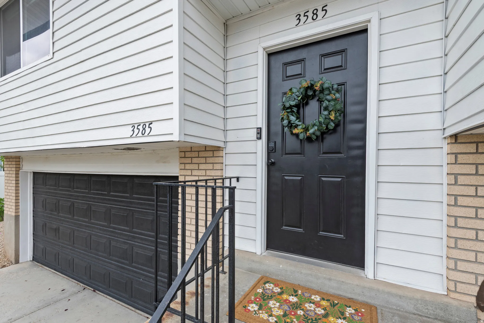 View of exterior entry with brick siding and an attached garage