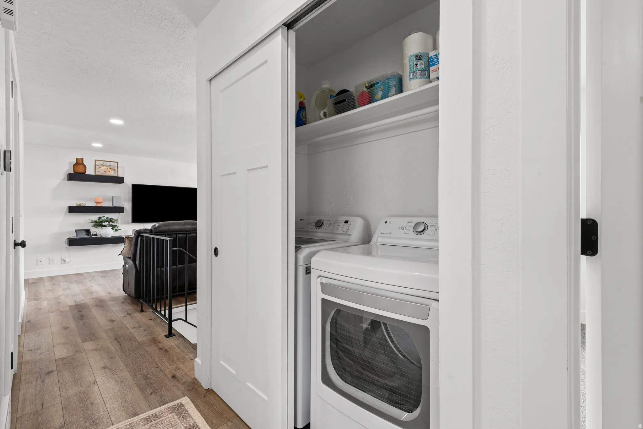 Laundry area featuring light wood-style flooring, recessed lighting, and independent washer and dryer