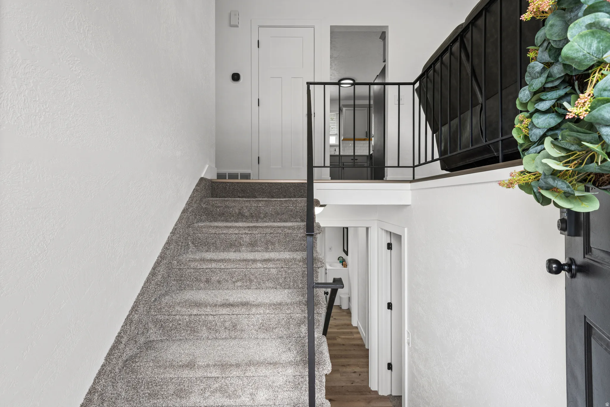 Stairway featuring a textured wall and wood finished floors