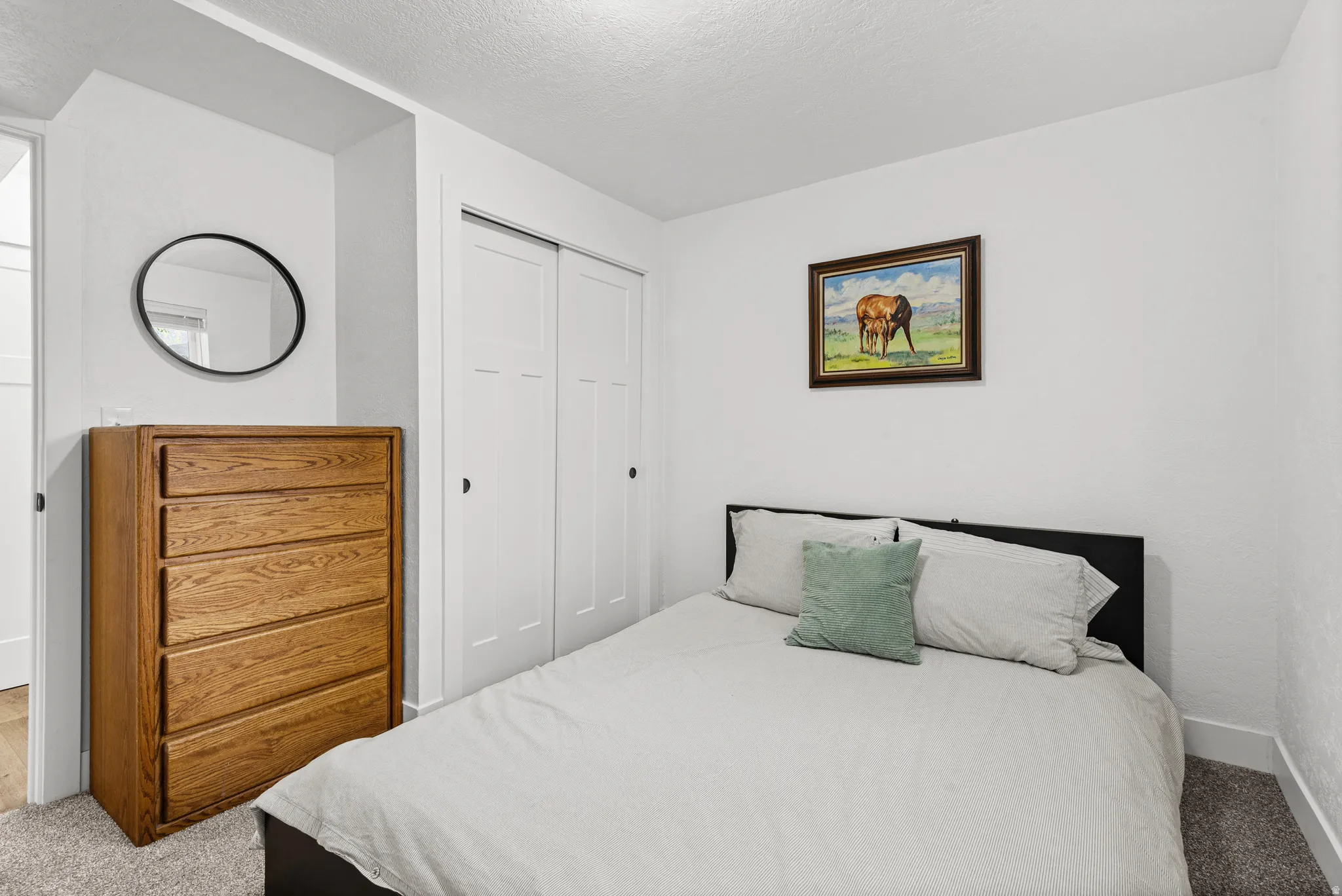 Carpeted bedroom with a closet and a textured ceiling