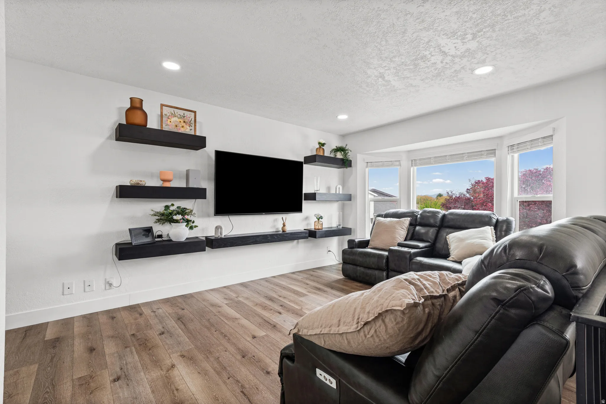 Living room featuring hardwood / wood-style flooring, a textured ceiling, and recessed lighting