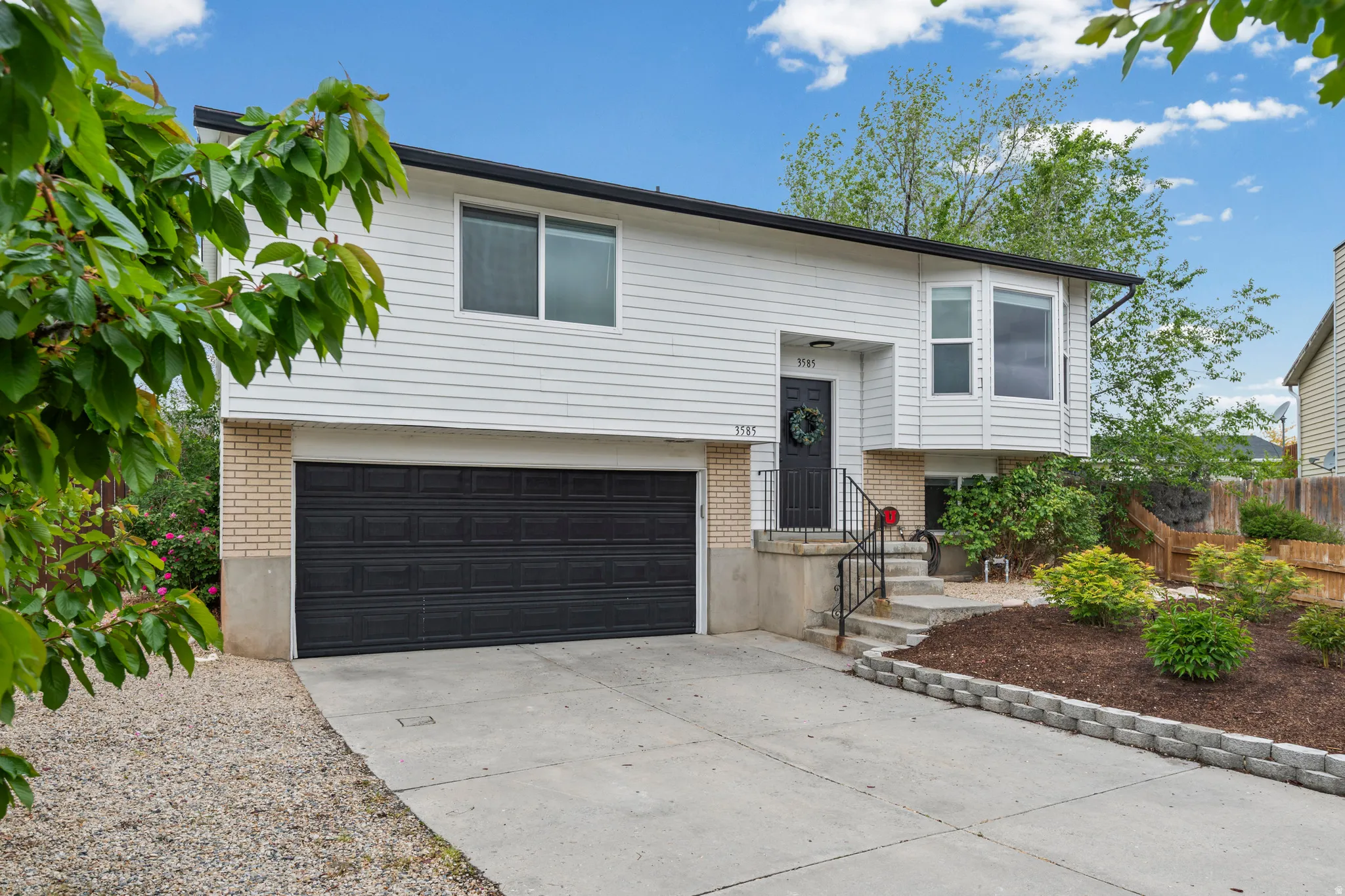 Split foyer home featuring brick siding, concrete driveway, and a garage