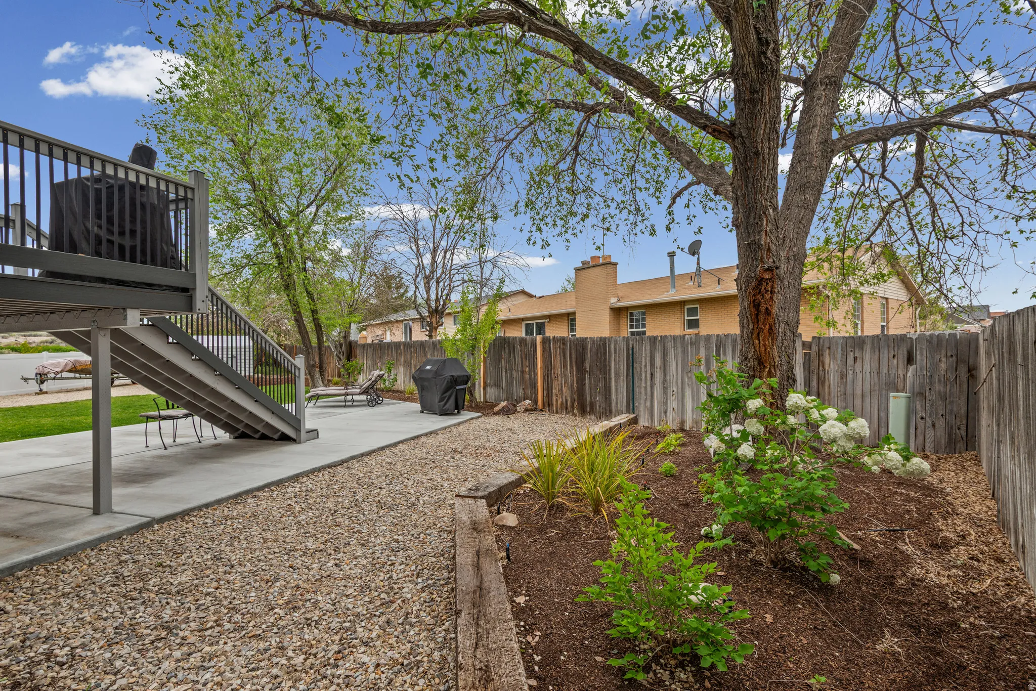Fenced backyard featuring a patio area and a wooden deck