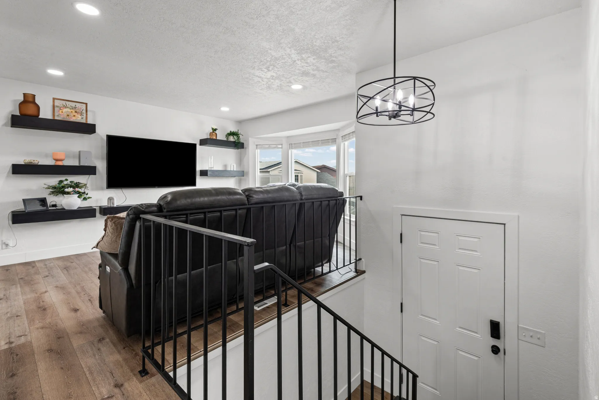 Living room featuring hardwood / wood-style flooring, recessed lighting, and a textured ceiling