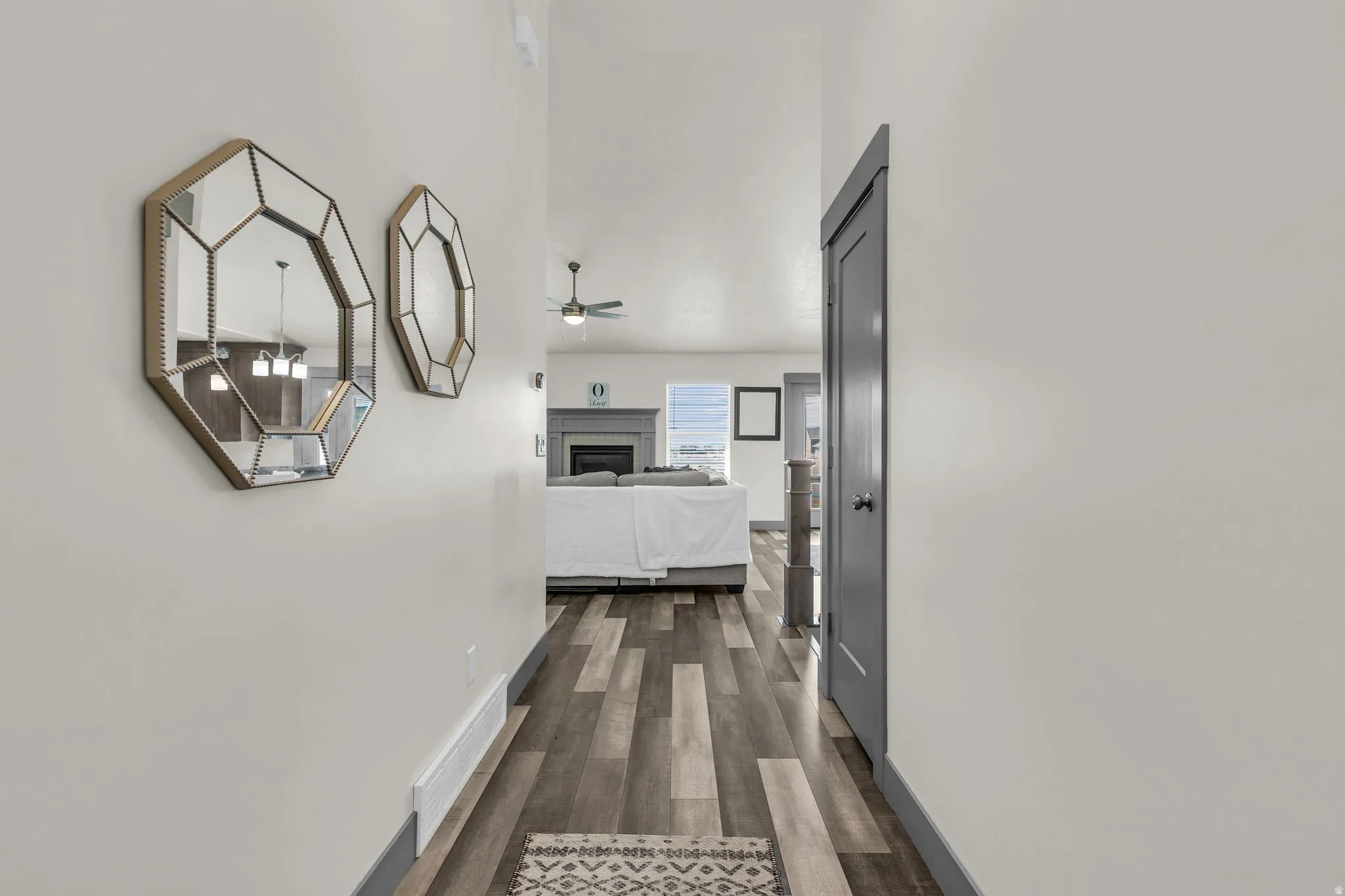 Corridor with dark wood-type flooring and baseboards