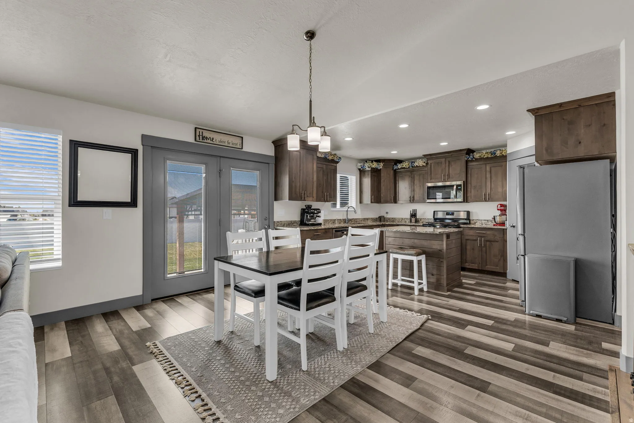 Dining area with dark wood-type flooring and recessed lighting