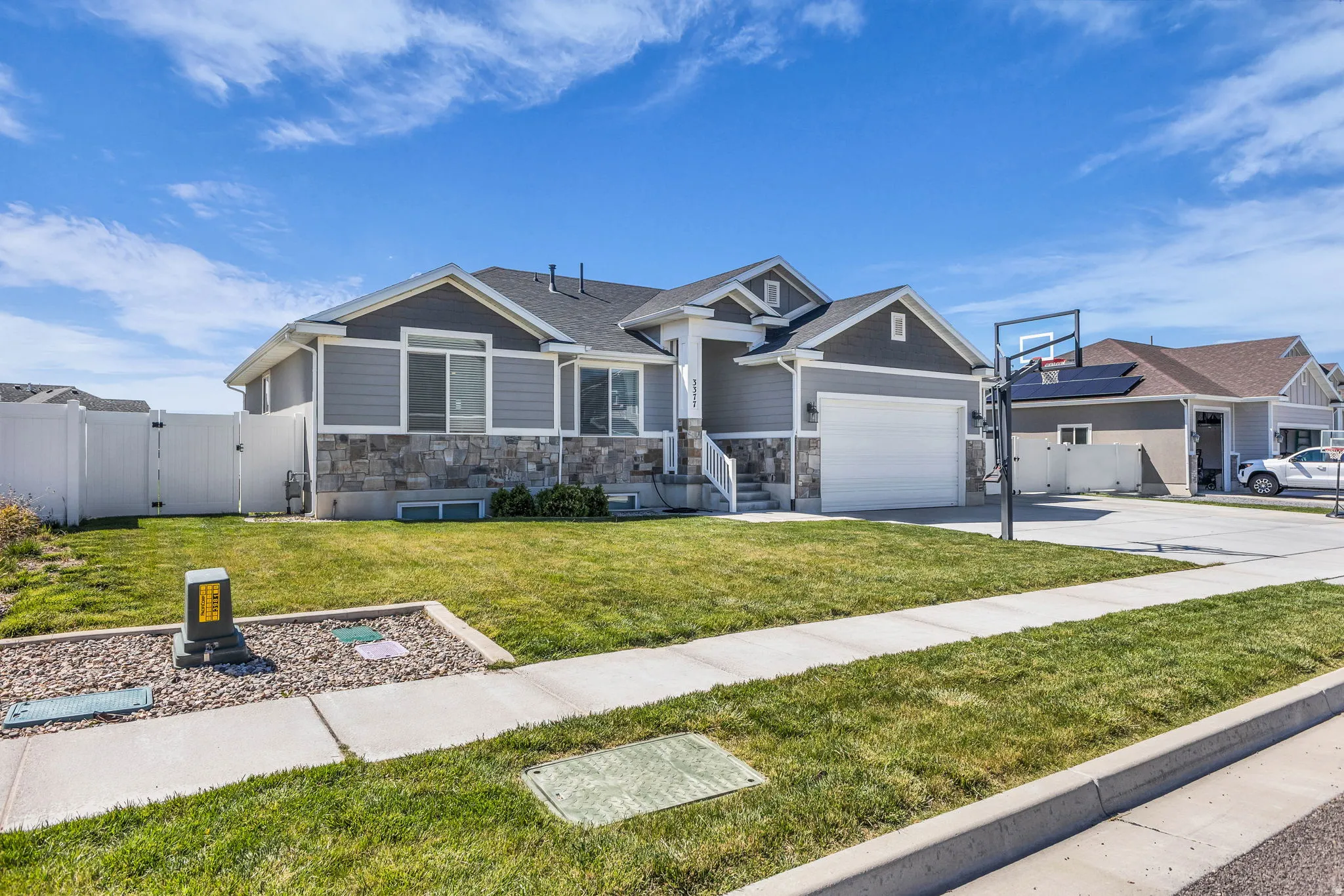 Craftsman-style house with a gate, stone siding, concrete driveway, and an attached garage
