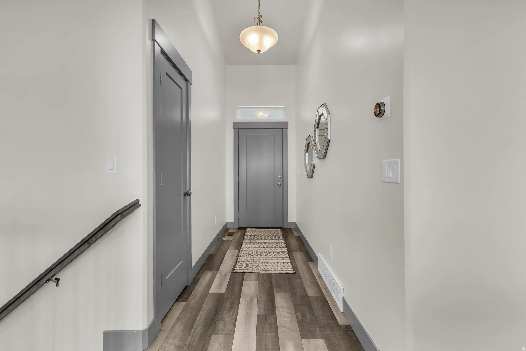 Doorway with wood finished floors and baseboards