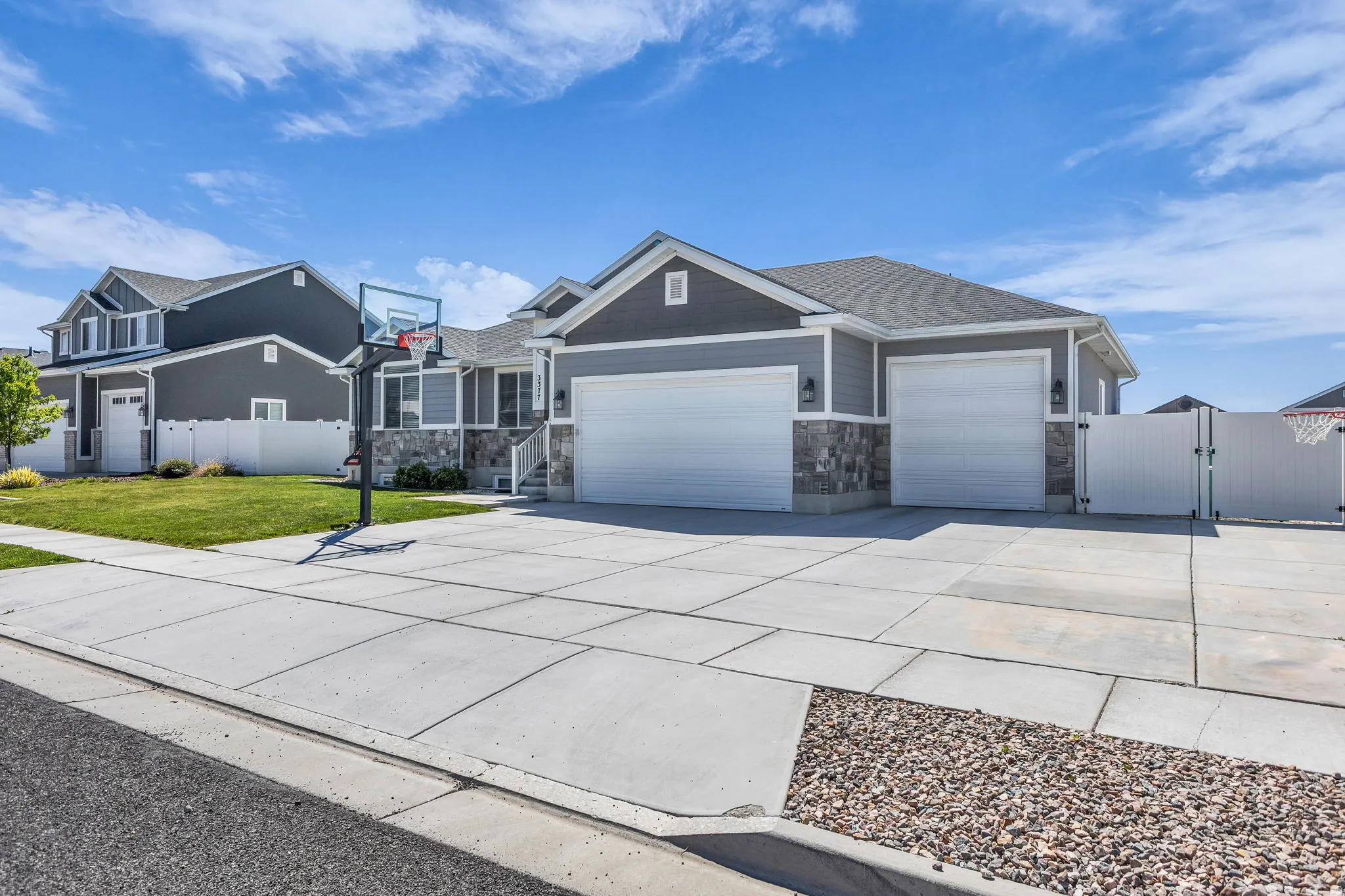 Craftsman house featuring a gate, a garage, concrete driveway, and stone siding