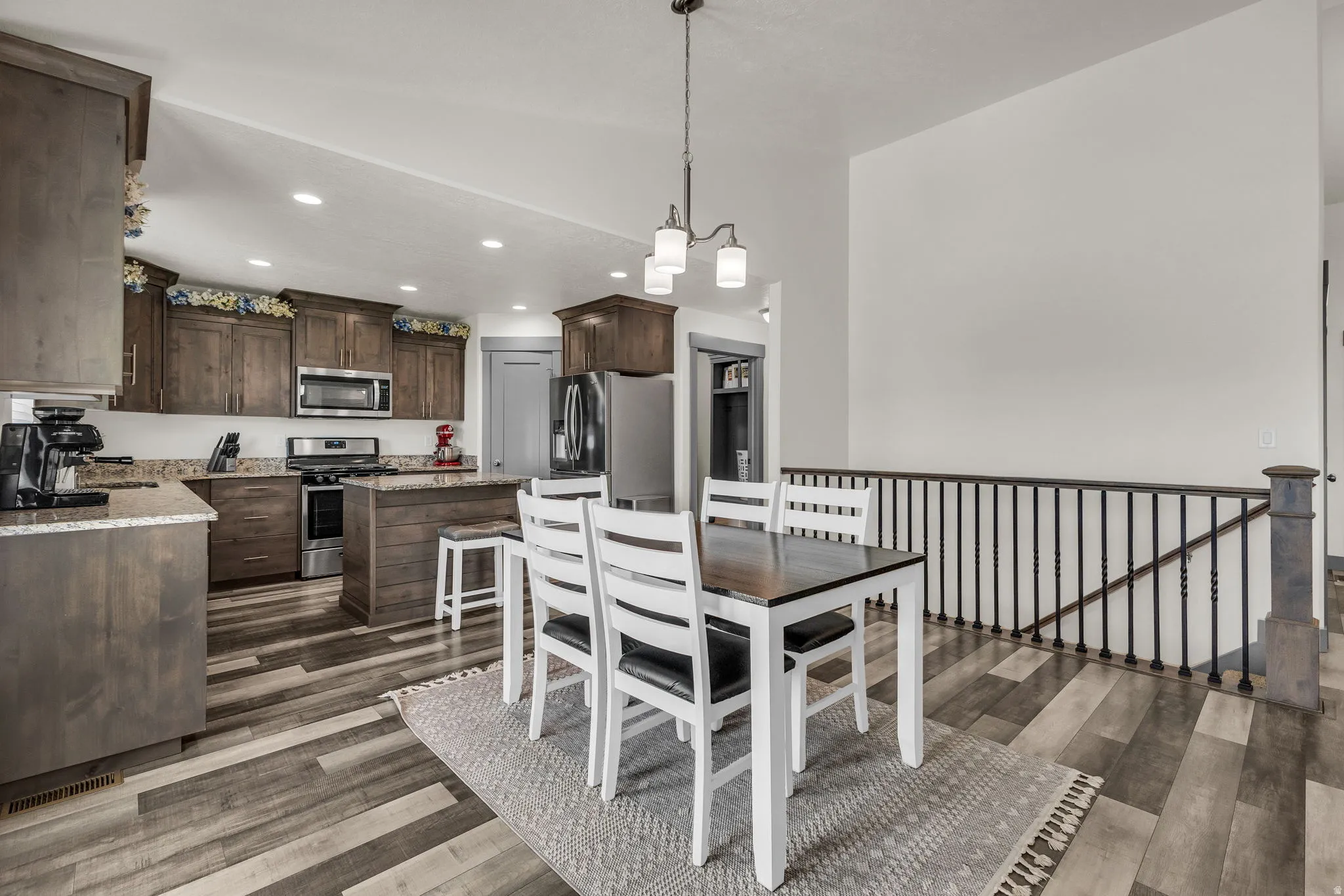 Dining room with dark wood finished floors and recessed lighting