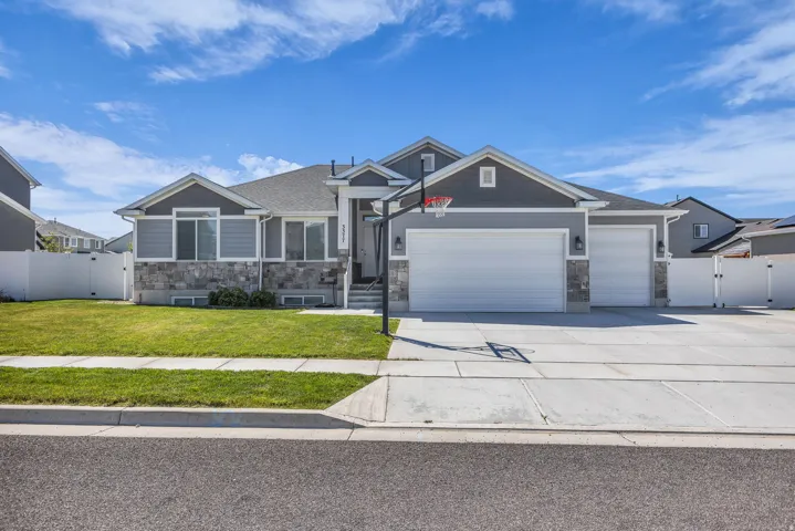 Craftsman-style home featuring a gate, stone siding, a garage, and concrete driveway